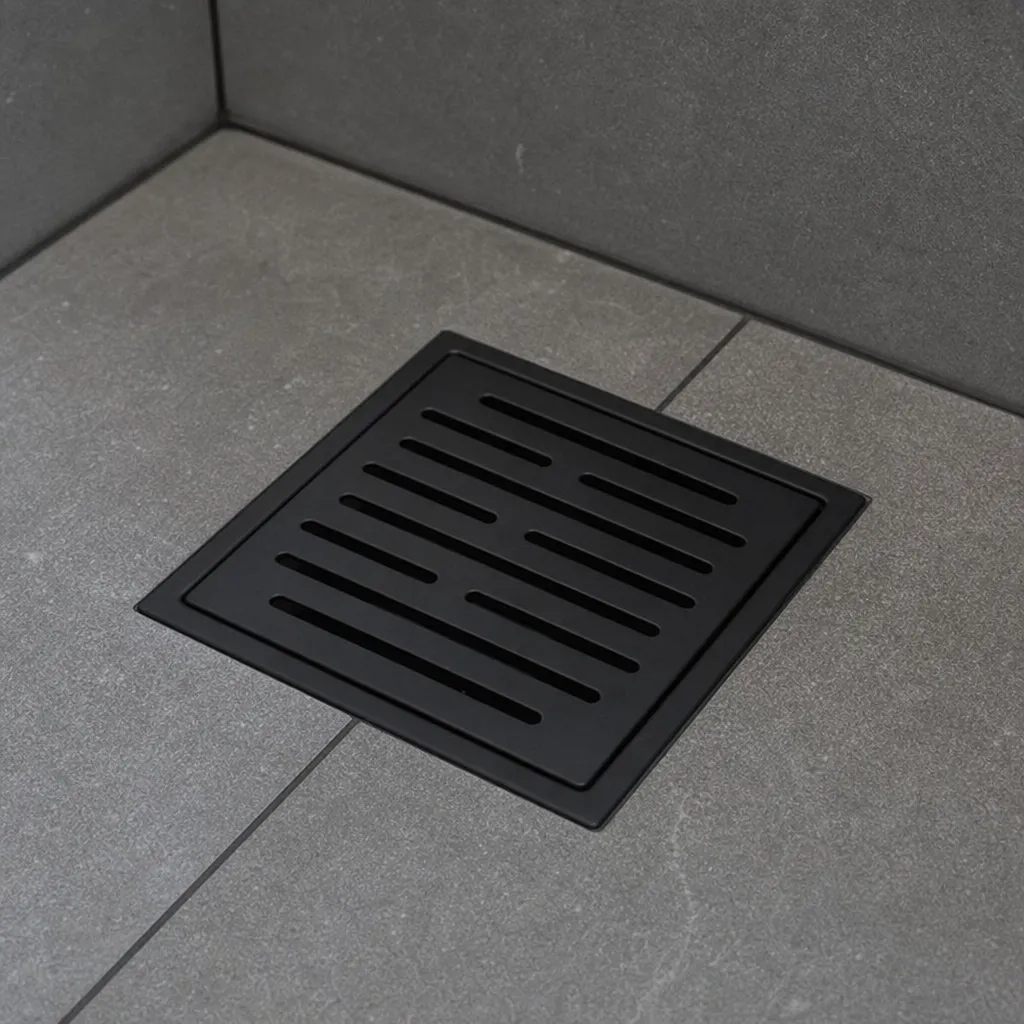 Gros plan sur une grille de douche décorative, noire mate et épurée, dans une douche carrelée